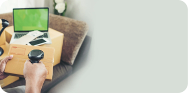 A hand is scanning a barcode on a package.